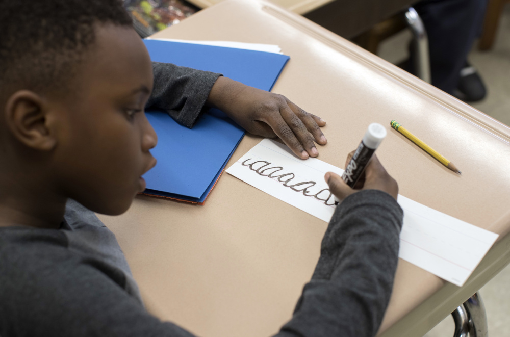 A third-grader practices his cursive handwriting at Public School 166 in the Queens borough of New York.
