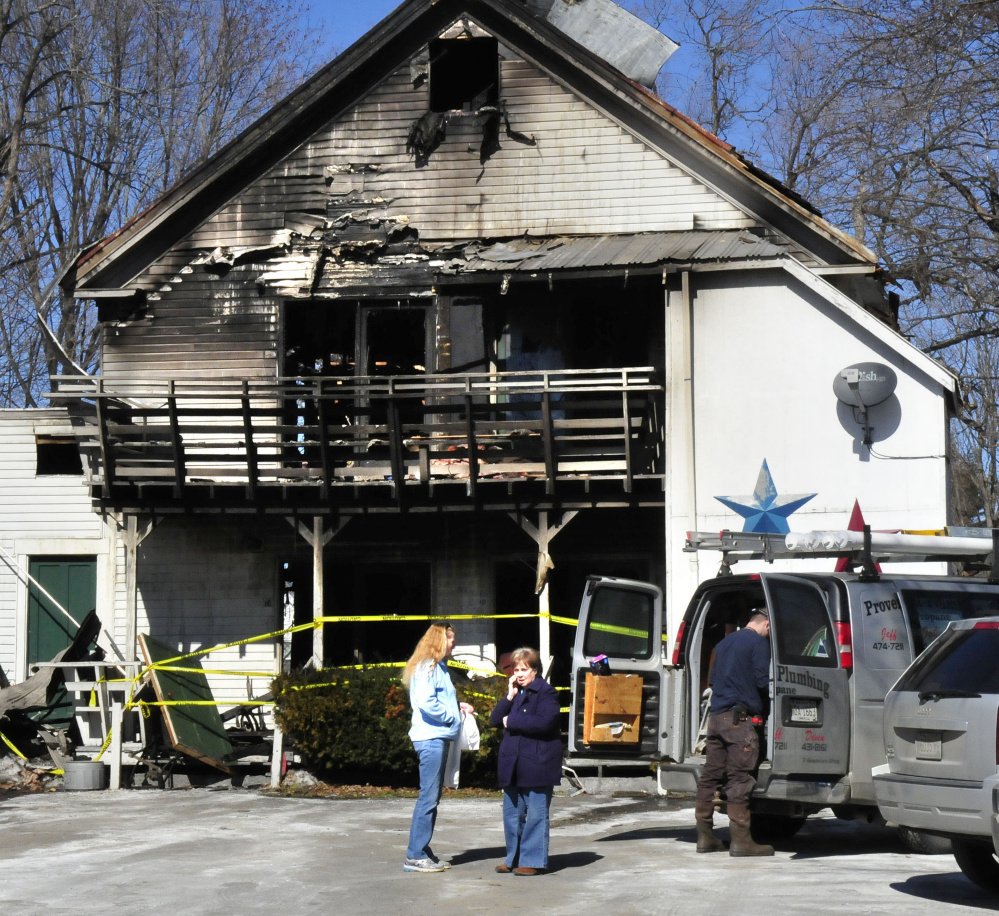 Virginia Weems, right, who owns the apartment complex at 152 Main St. in Madison that was heavily damaged in a blaze, stands beside tenant Barbara Turner on Monday. Four apartments were gutted, while Turner's unit sustained smoke damage.