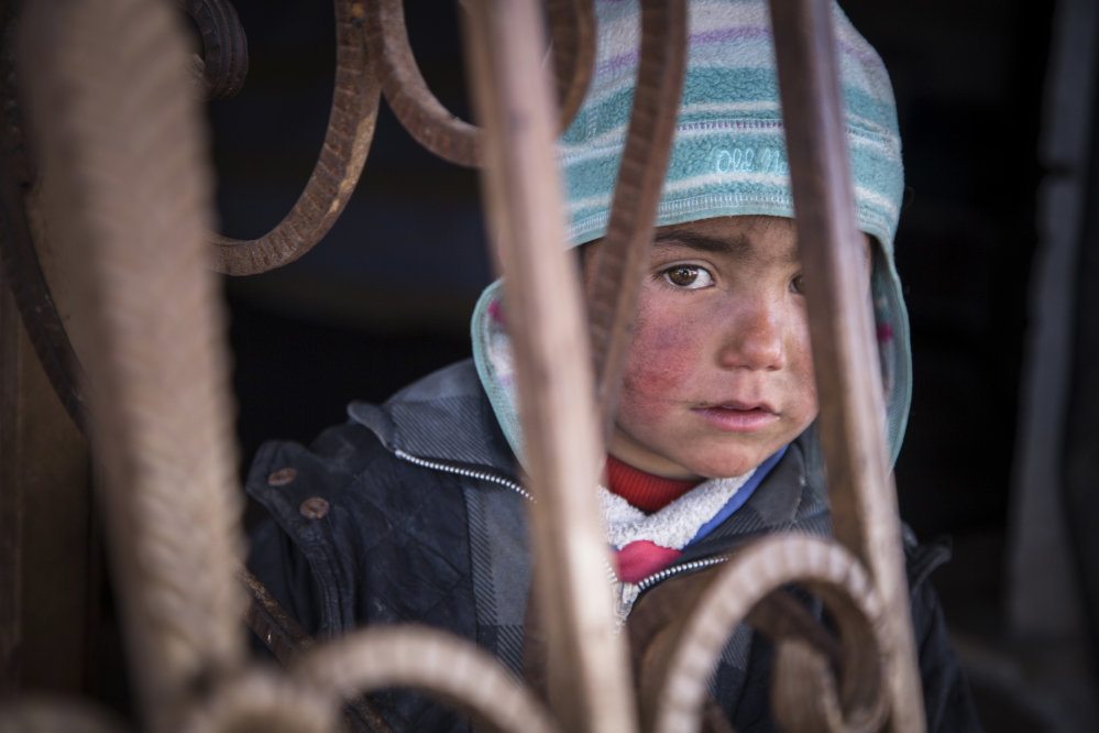 A Syrian child looks out from an abandoned gas station where he and his family now live. A new report by Save the Children says Syrian children are showing symptoms of "toxic stress" from war exposure, and attempting self-harm and suicide.