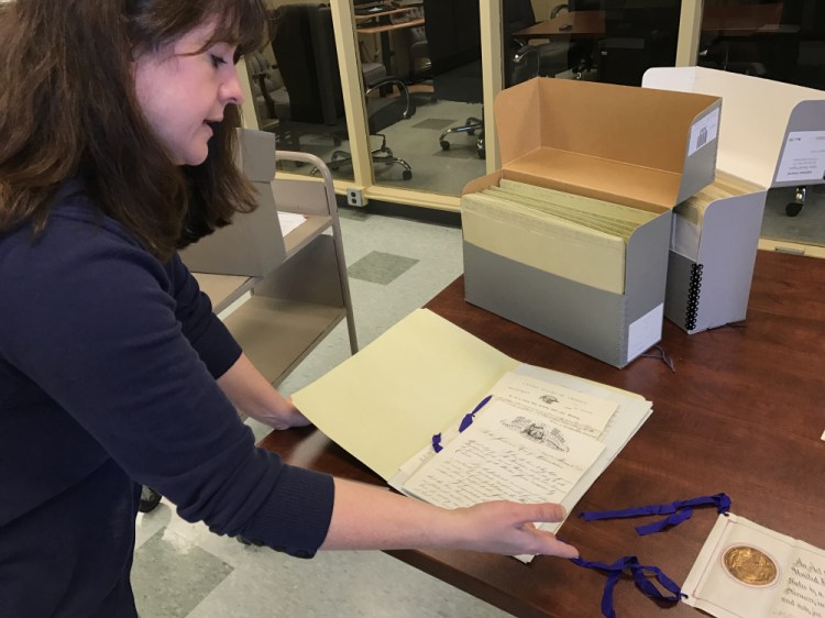Archivist Heather Moran displays paperwork from Maine's collection of documents connected to the state's ratification of the 13th Amendment abolishing slavery in 1865. The Maine State Archives is asking for the public's help transcribing digital images of such documents.