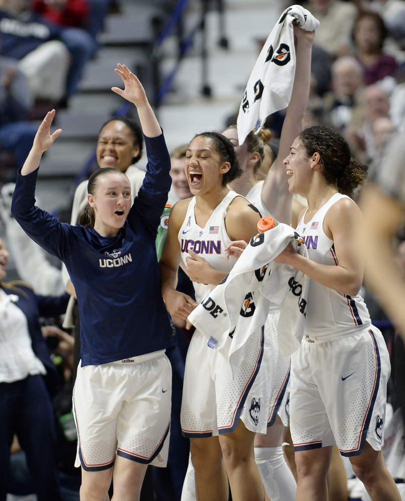 Connecticut's Tierney Lawlor, left, celebrates with Gabby Williams, center, and Kia Nurse, right, during the second half of Monday night's game against South Florida in the American Athletic Conference tournament at Uncasville, Conn.