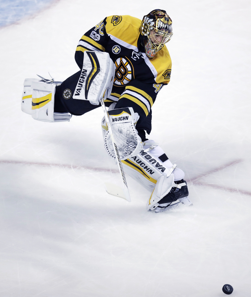 Bruins goalie Tuukka Rask skates out of the crease to clear the puck during the first period.