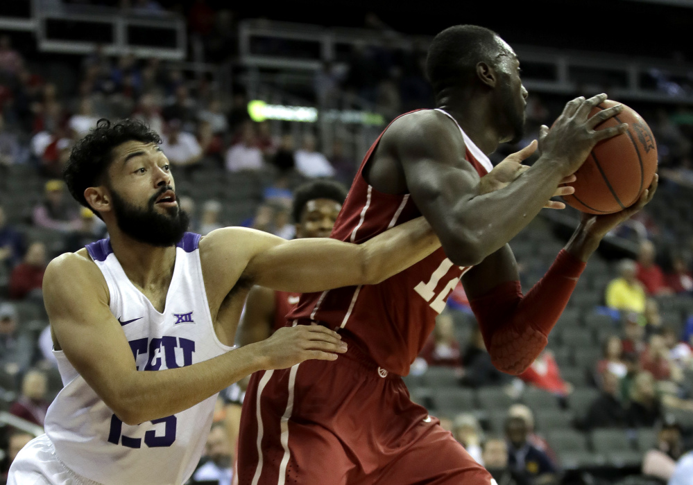 TCU's Alex Robinson, left, tries to steal the ball from Oklahoma's Khadeem Lattin during the first half of an NCAA college basketball game in the Big 12 Conference tournament Wednesday, March 8, 2017 in Kansas City, Mo. (AP Photo/Charlie Riedel)