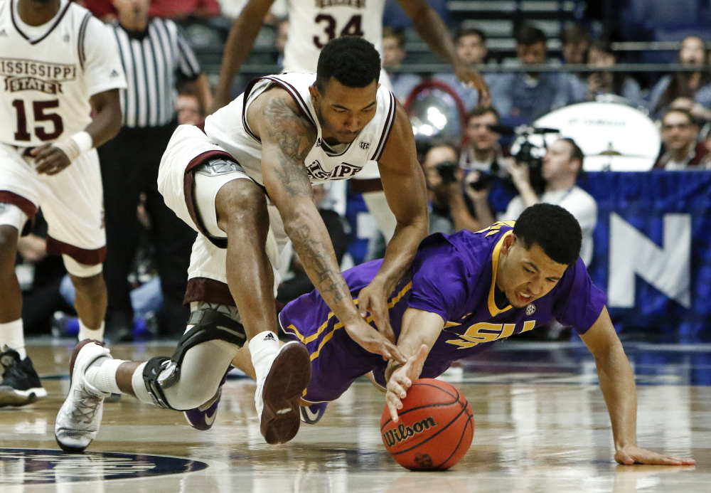 Mississippi State guard Xavian Stapleton and LSU guard Skylar Mays, right, dive for the ball during the first half of an NCAA college basketball game at the Southeastern Conference tournament Wednesday in Nashville, Tenn. (Associated Press/Wade Payne)