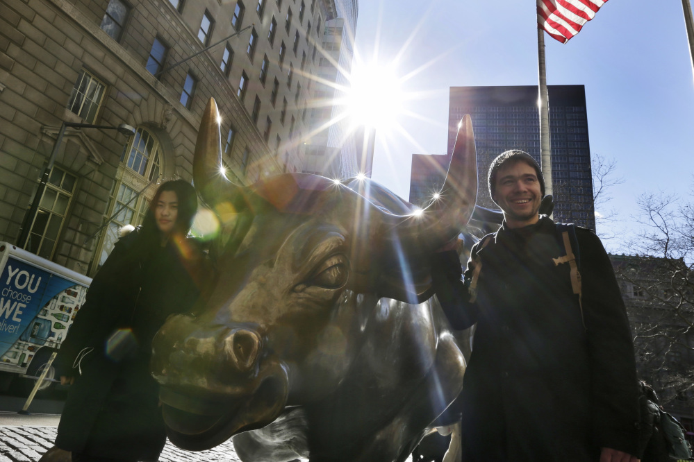 Passers-by pose with "Charging Bull," a bronze sculpture in New York's Financial District. Since the stock market hit bottom in 2009, a $10,000 investment in the largest U.S. mutual fund has turned into nearly $42,000.