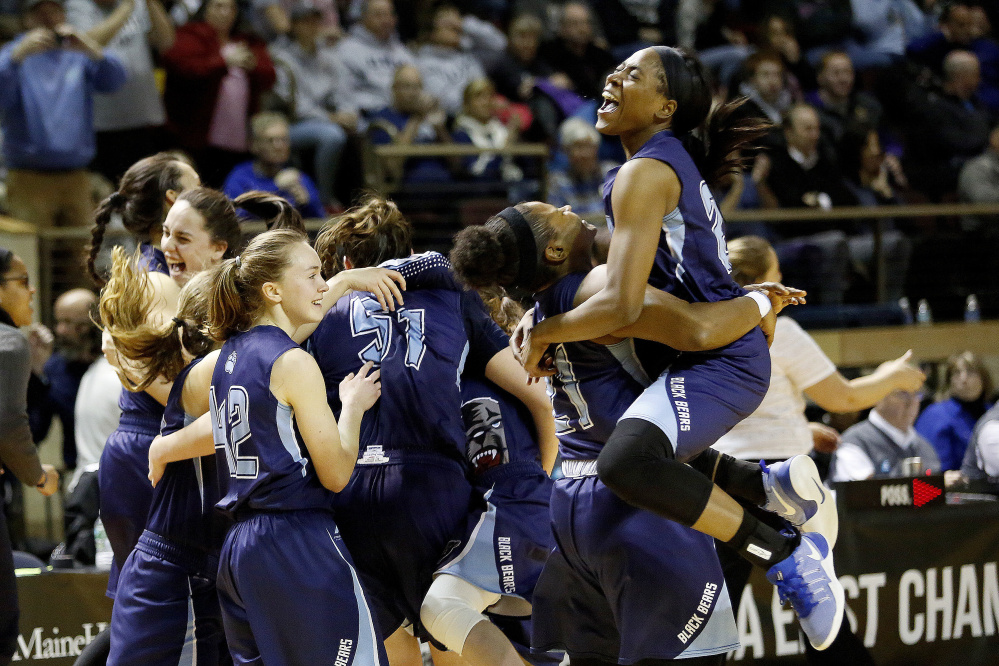 UMaine's Tanesha Sutton jumps into the arms of teammate Sheraton Jones after UMaine beat UNH in the semifinals of the America East Tournament at the Cross Insurance Arena Sunday.