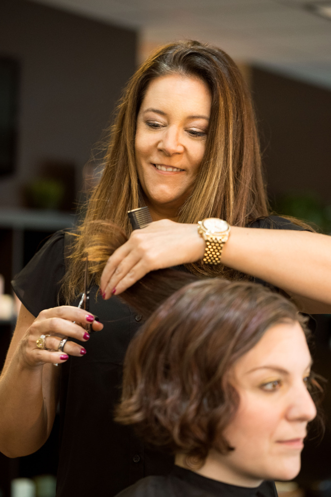 Christy Legere cuts a client's hair at Magnolia's Salon in Sanford, which she owns with her sister, Kelly Clark. In the Skinny on Skin program, they were trained to spot early signs of skin cancer in their clients.
