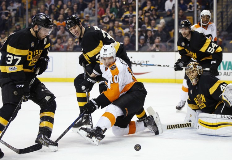 Philadelphia's Brayden Schenn, center front, battles Boston's Patrice Bergeron, left, and Zdeno Chara, center back, for a rebound during the first period of the Bruins' 2-1 win Saturday in Boston.