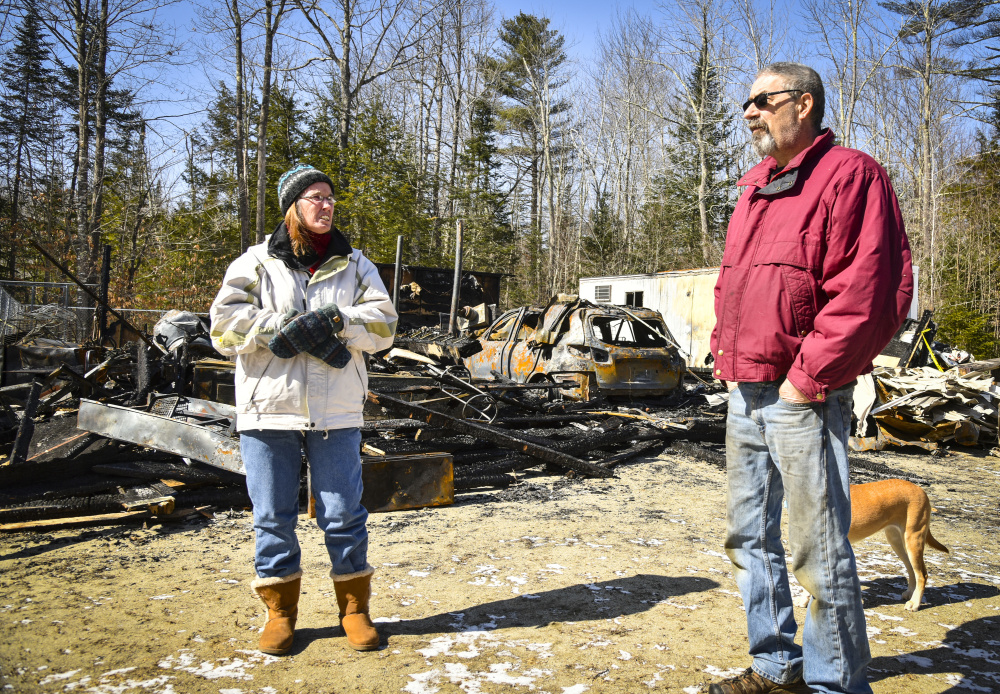 Lynn and and Paul Beaudin stand in front of the charred remains of their garage on Route 135 in Monmouth after a fire on March 2. The Beaudins are stunned at how quickly the detached garage burned but are relieved that they and their house were spared.