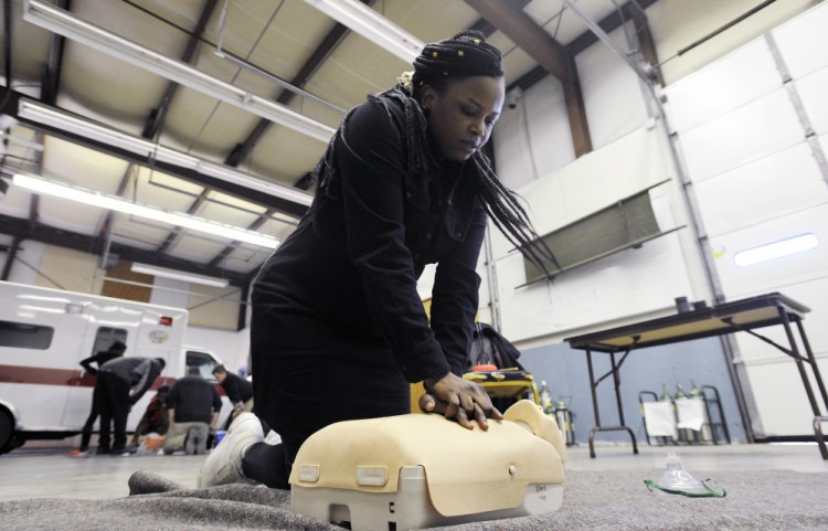 Jolly Ntirumenyerwa of Portland, who was a doctor in the Democratic Republic of Congo, practices her CPR technique on a training mannequin last week at SMCC. Her professional credentials aren't recognized in the U.S., so she's training to be an EMT.
