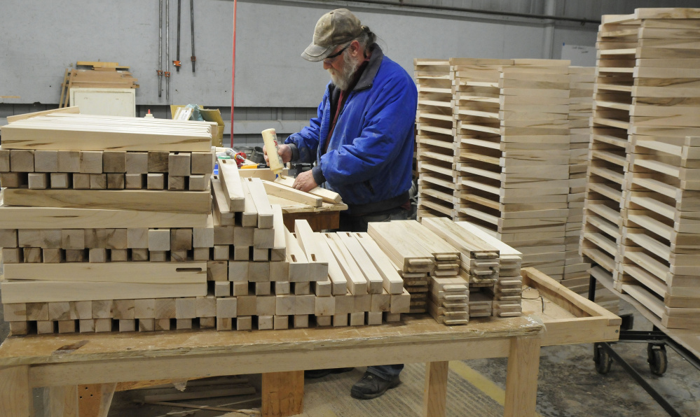 Ernest Edmunds glues chair legs at Maine Made Furniture in Wilton. Among the furniture-maker's new contracts is a 1,000-piece furniture deal with Sunday River.