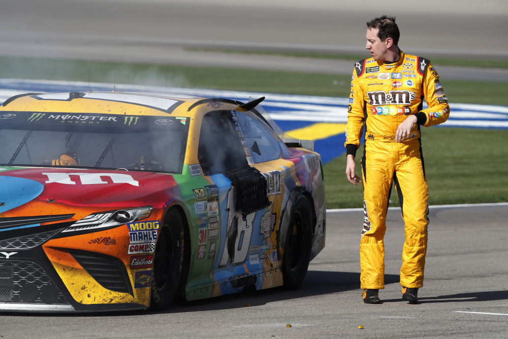 Kyle Busch looks at his smoking car at the end of the NASCAR race Sunday at Las Vegas Motor Speedway. One NASCAR official said Busch and Joey Logano likely won't face harsh penalties after a fight on pit road.