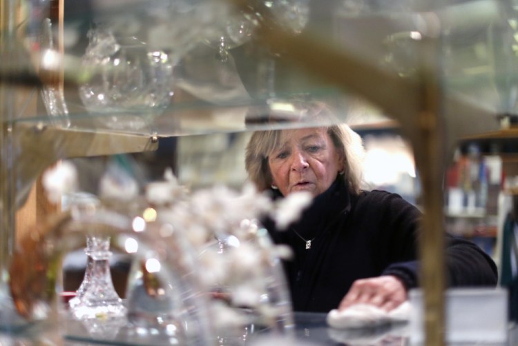 Mary Ellen Pallozzi, owner of Ireland's Crystal & Crafts, dusts off her crystal selections. Photos by Ben McCanna/Staff Photographer