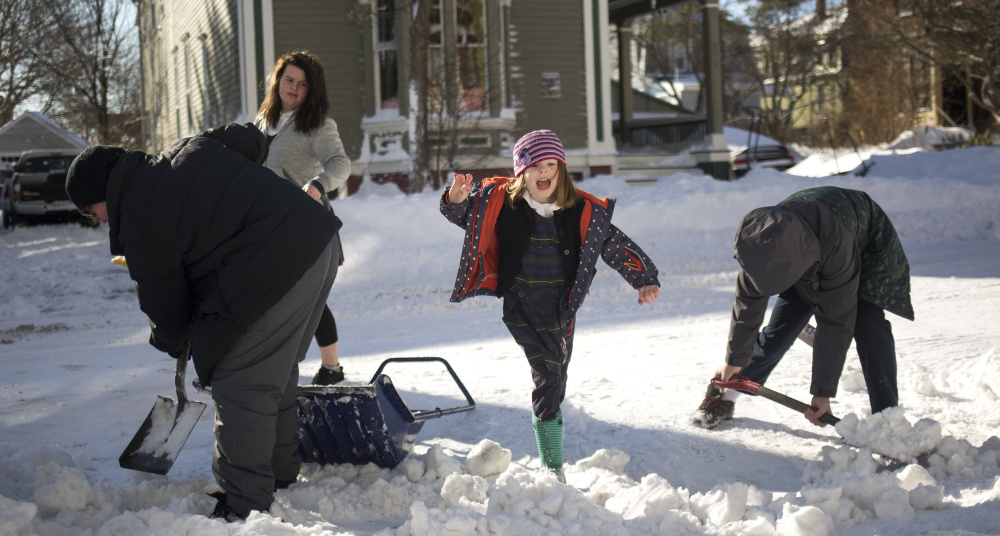 Lola Fitzgerald, 5, jumps over a pile of snow as her family shovels a driveway in Portland's West End on Wednesday. The storm contributed to one of the city's snowiest seasons in recent years.