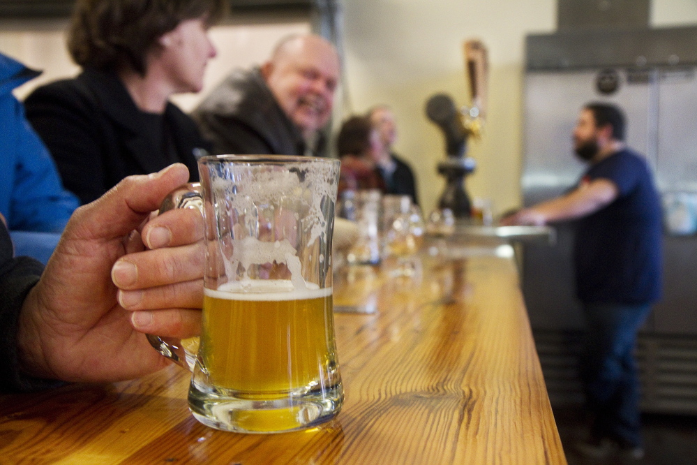Patrons sample brews in the tasting room of Biddeford's Banded Horn Brewing Co. in 2014. Maine now has over 90 breweries, up from 34 in 2011.