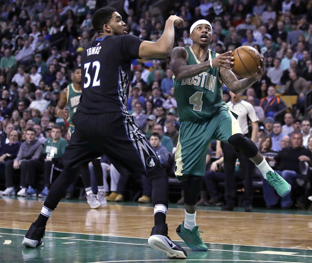 Boston Celtics guard Isaiah Thomas drives to the basket against Minnesota center Karl-Anthony Towns during Wednesday's game in Boston. Thomas will miss the next two games for Boston with a bone bruise to his right knee. (Associated Press/Charles Krupa)
