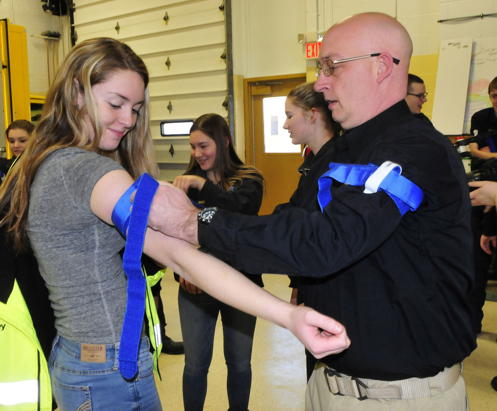 Homeland Security trainer Paul Brooks assists student Kirsten Gordon with applying a tourniquet during training on stopping bleeding Thursday at Mid-Maine Technical Center in Waterville.