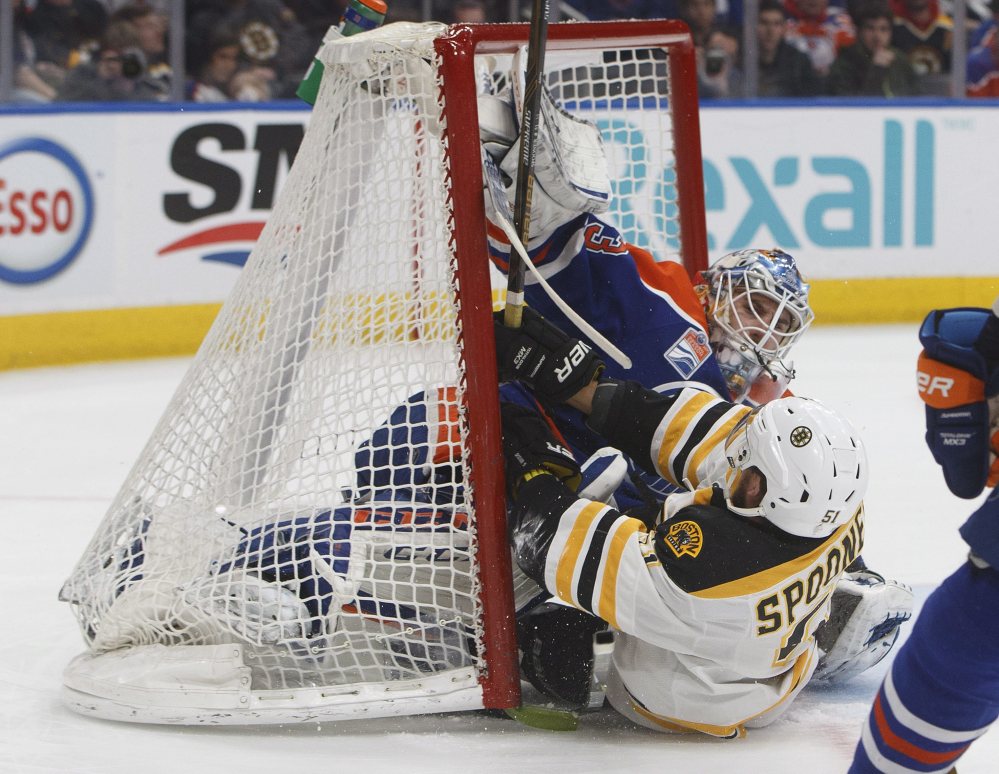 Boston's Ryan Spooner crashes into Oilers goalie Cam Talbot in the first period Thursday night in Edmonton, Alberta.