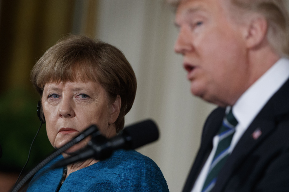 German Chancellor Angela Merkel listens as President Trump speaks during their joint news conference in the East Room of the White House in Washington on Friday.