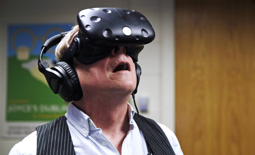Joseph Nugent, a Boston College English professor, wears virtual reality goggles at the school's virtual reality lab in Boston. College students in Boston are developing a virtual reality game based on James Joyce's ponderous tome "Ulysses." Nugent says the goal of "Joycestick" is to expose new audiences to the works of one of Ireland's most celebrated authors and to give a glimpse of how virtual reality can be used to enhance literature.
