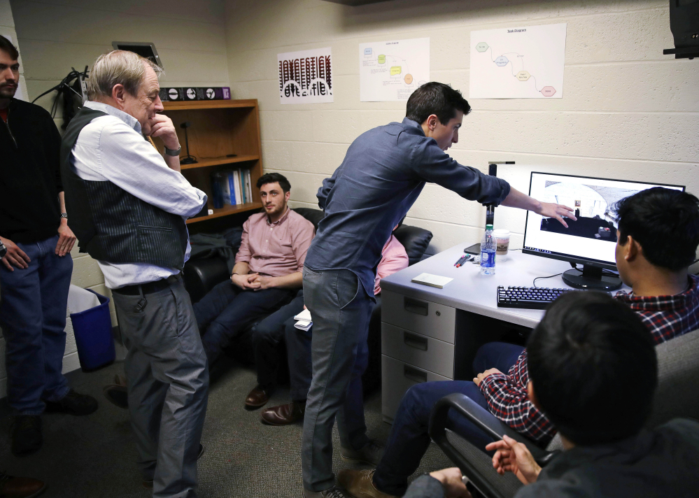 Joseph Nugent, an English professor at Boston College, left, watches as student Evan Otero points out a graphic on a work station at the school's virtual reality lab. Students are developing a virtual reality game based on James Joyce's "Ulysses."