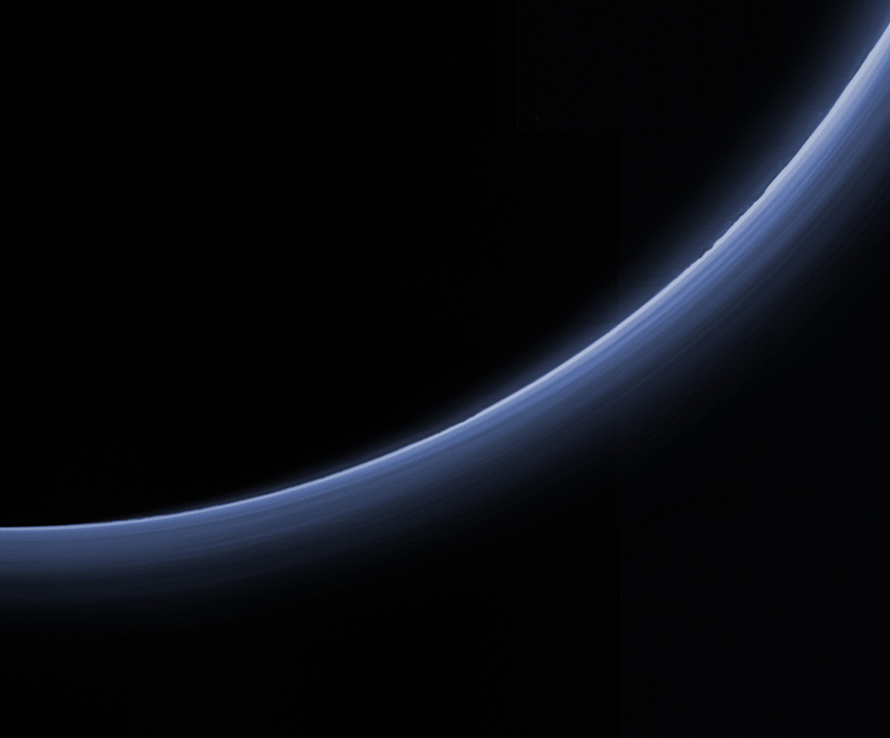 Haze around Pluto appears blue in this image captured by New Horizons and processed to replicate the color a human eye would see.