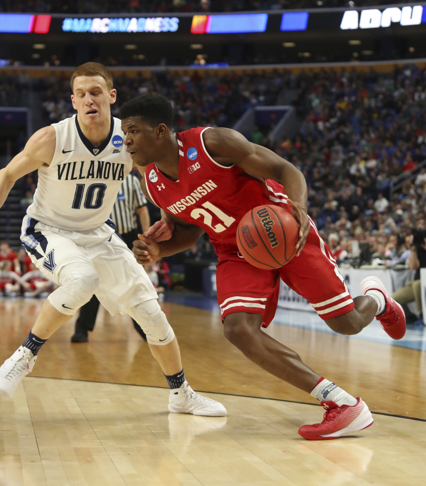 Wisconsin guard Khalil Iverson, right, drives to the basket against Villanova guard Donte DiVincenzo during the first half of a second-round men's college basketball game in the NCAA Tournament on Saturday in Buffalo, N.Y. Wisconsin knocked off the defending national champion, 65-62. (Associated Press/Bill Wippert)
