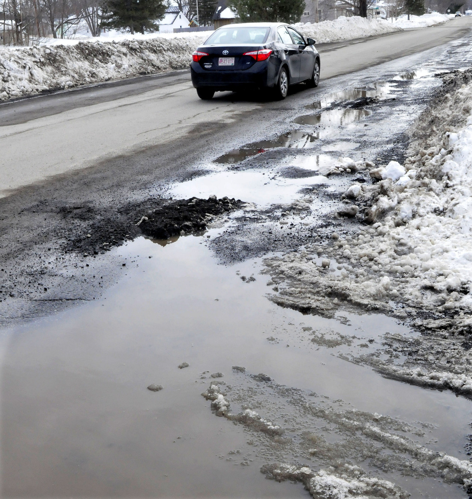 Snow melts near potholes on Greenwood Road in Skowhegan, where one official says he's seen "a lot more problems than usual."