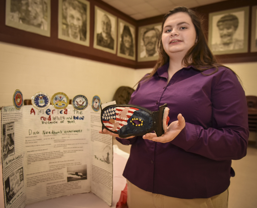 Monmouth Academy sophomore Jessica Withee shows off a mask she made in honor of veteran Dave Needham, a Navy sonar technician, the focus of her social studies project.