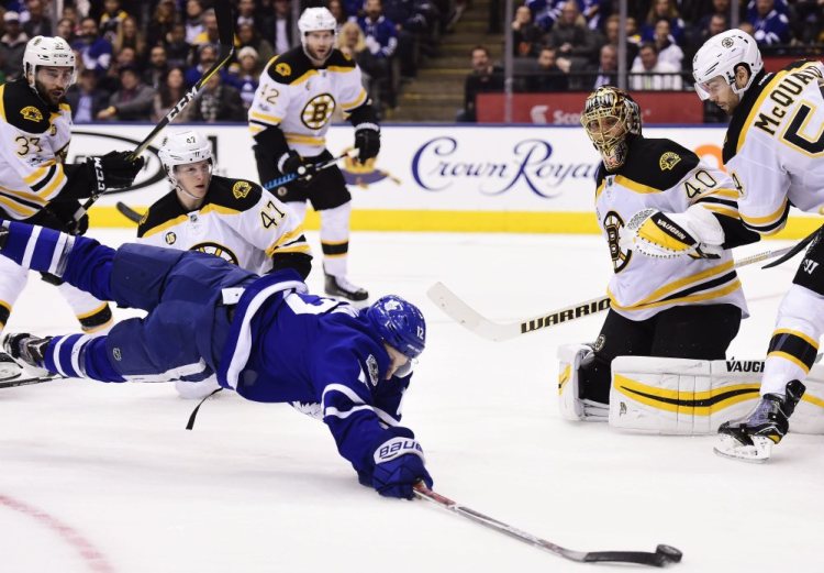 Maple Leafs right wing Connor Brown dives for the puck as Bruins defenseman Torey Krug (47), goalie Tuukka Rask and defenseman Adam McQuaid watch during the second period Monday night in Toronto. The Maples Leafs went on to a 4-2 win