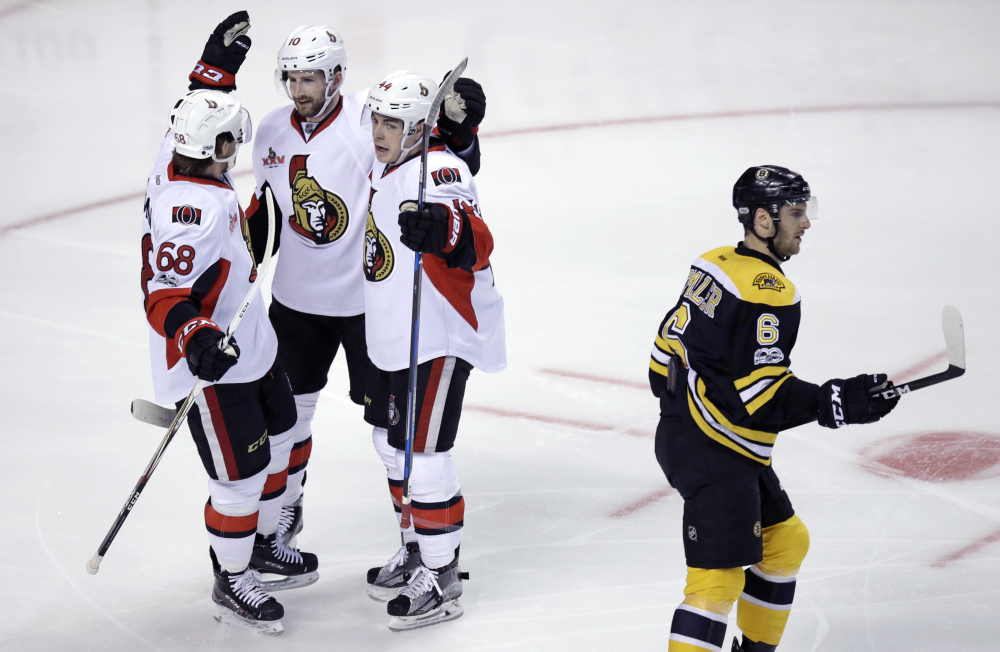Ottawa Senators left wing Tom Pyatt, second from left, is congratulated by Mike Hoffman and Jean-Gabriel Pageau after his goal during the first period against the Boston Bruins. At right skating past is Bruins defenseman Colin Miller.