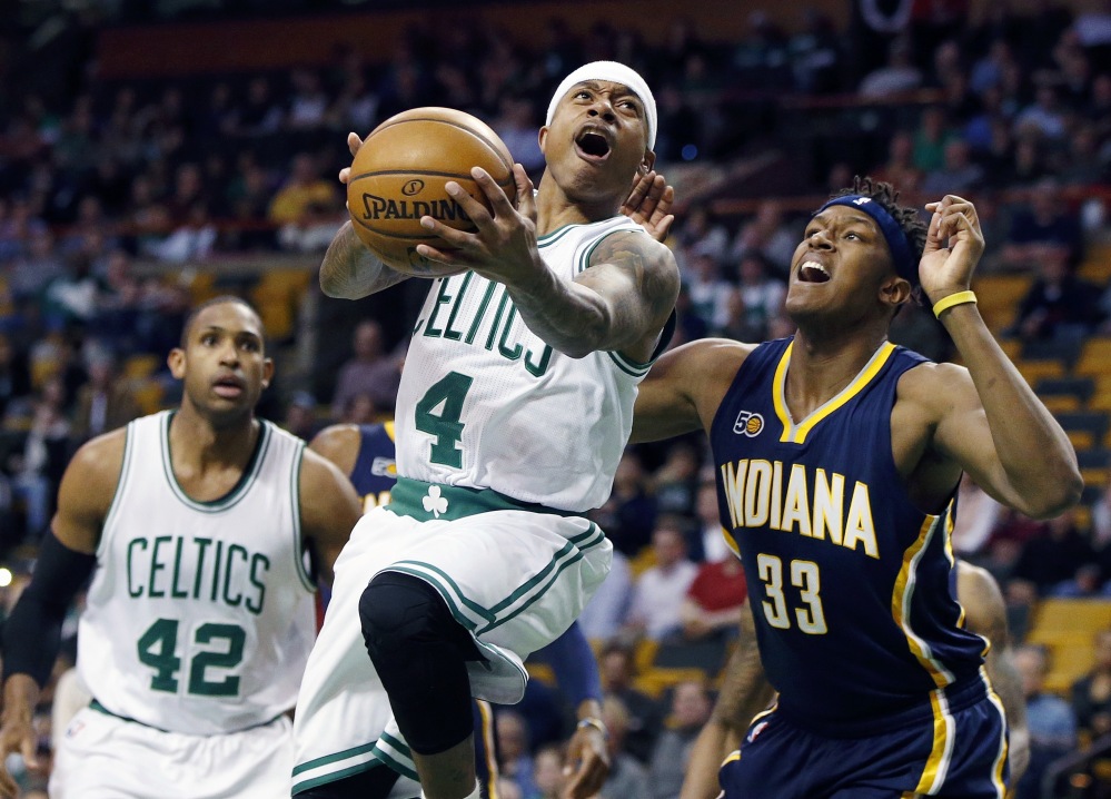 Isaiah Thomas of the Boston Celtics, center, goes up to shoot against Indiana's Myles Turner (33) during the first quarter of Wednesday's game in Boston. (Associated Press/Michael Dwyer)