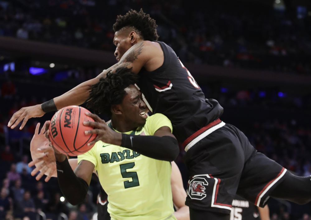 Baylor forward Johnathan Motley, left, looks to pass against South Carolina forward Chris Silva during the first half of South Carolina's 70-50 win Friday in New York.
