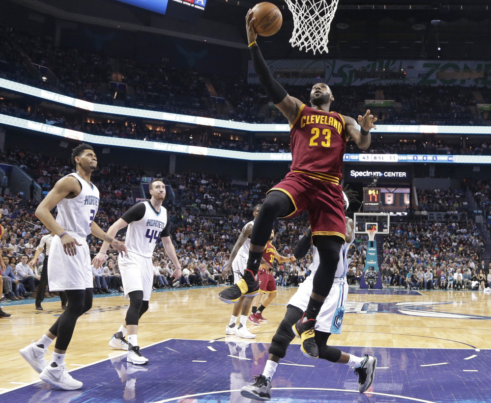 Cleveland's LeBron James drives to the basket during the Cavaliers' 112-105 win over Charlotte on Friday in Charlotte, N.C. James had 32 points, 11 assists and nine rebounds.