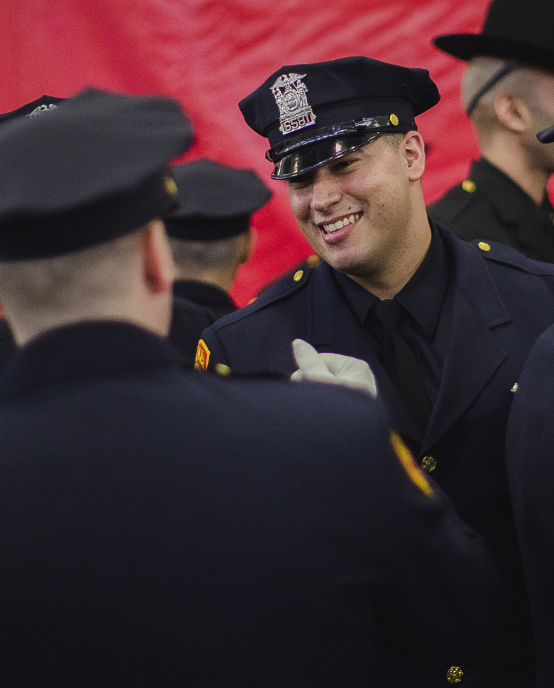 Matias Ferreira celebrates during graduation from the Suffolk County Police Department Academy in Suffolk, N.Y., Friday. Ferreira is a former Marine lance corporal who lost his legs below the knee in Afghanistan in 2011.
