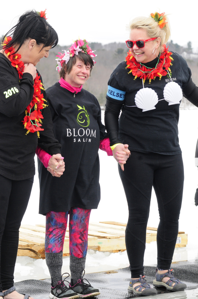 From left, Tricia Lynn Trial, Laura Lucas and Kimberly Stoneton get psyched up to jump into Maranacook Lake on Saturday during the Maine Law Enforcement Torch Run Ice Out Plunge on at Winthrop's town beach.