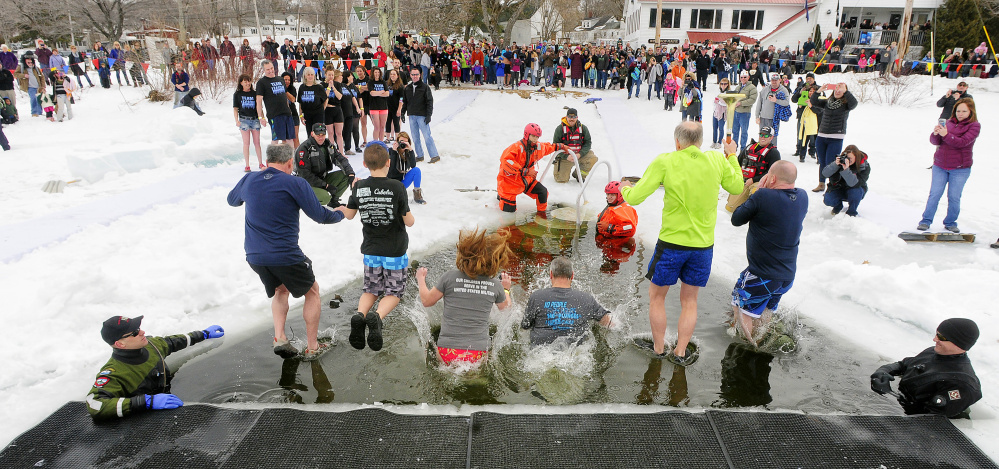 Jumpers leap into Maranacook Lake during the Maine Law Enforcement Torch Run Ice Out Plunge on Saturday at Winthrop's town beach.