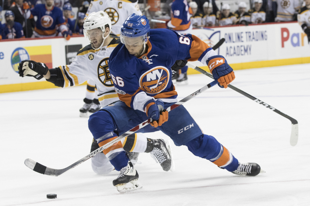 New York Islanders right wing Joshua Ho-Sang controls the puck as he skates against Boston Bruins defenseman Colin Miller during the second period of their game in New York on Saturday night. The Bruins won 2-1. (Associated Press/Mary Altaffer)