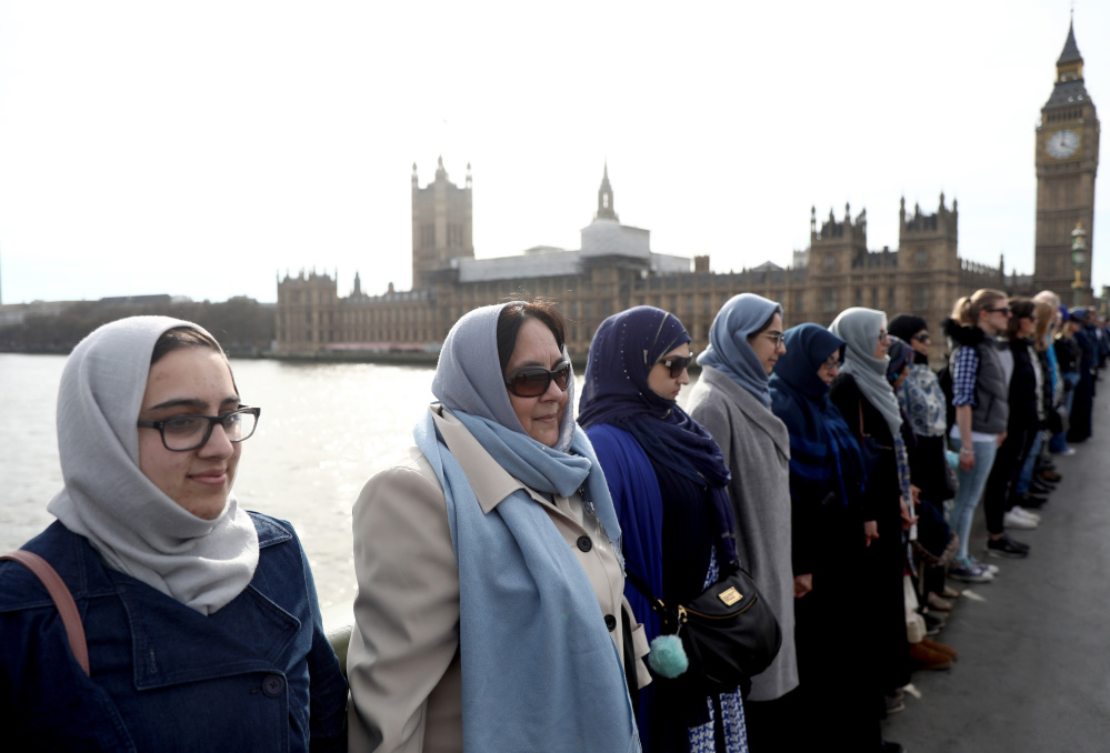 Participants in the Women's March gather on the Westminster Bridge to hold hands in silence Sunday to remember victims of the attack in London last week.
