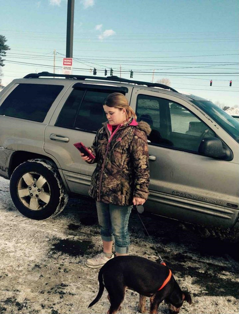 Nicole Bizier, 32, stands by her silver Jeep in the Pizza Hut parking lot with the dog she allegedly tried to sell to state animal welfare agents and Skowhegan police on Feb. 2.