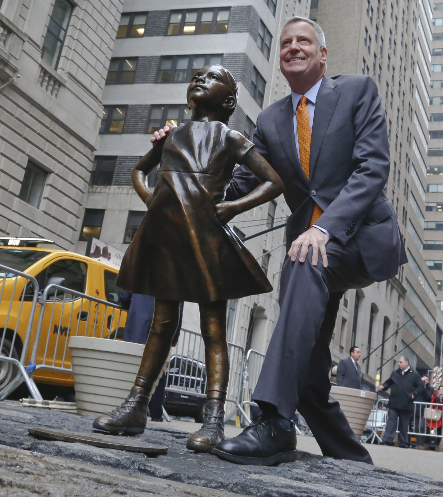 New York Mayor Bill de Blasio poses alongside the "Fearless Girl" statue.