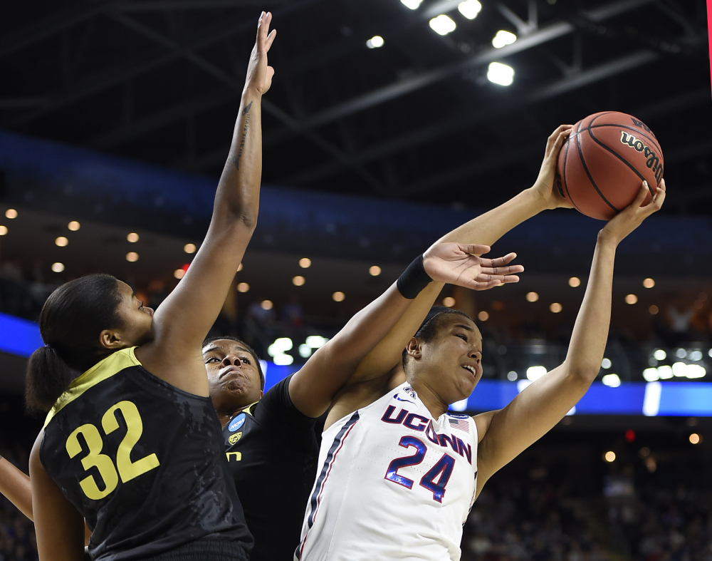 Oregon's Oti Gildon, left, and Ruthy Hebard, center, defend against Connecticut's Napheesa Collier during the first half the Huskies' 90-52 win in a regional final Monday in Bridgeport, Connecticut.