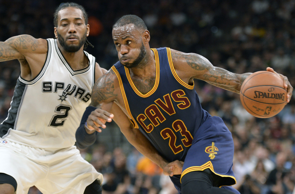 LeBron James of the Cleveland Cavaliers drives against Kawhi Leonard of the San Antonio Spurs in the first half Monday night. The Cavaliers lost and James left the game in the third quarter with an injury.