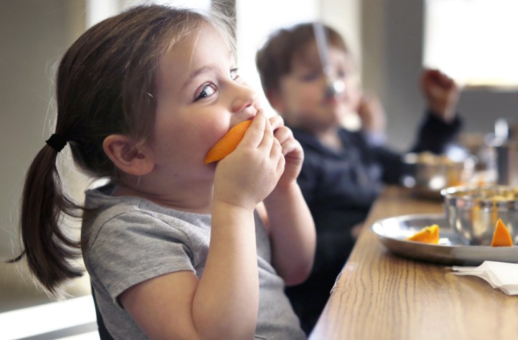 Camille Pitzer, 3, bites into a freshly sliced orange at MaineLy Childcare in South Portland.