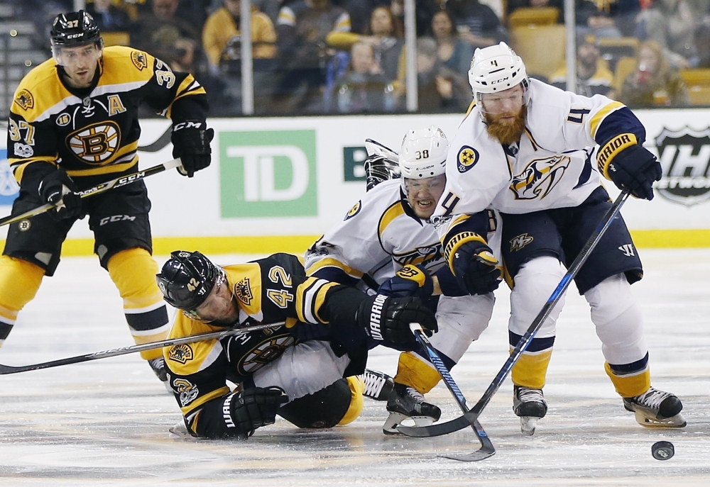 Boston's David Backes, 42, battles Nashville's Viktor Arvidsson, center, and Ryan Ellis for the puck during the second period of the Bruins' 4-1 win Tuesday in Boston.