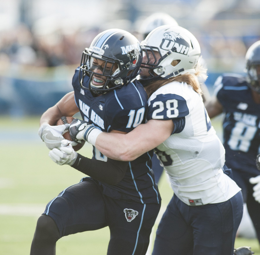 Orono, Maine—11-19-2016— UMaine's Micah Wrightcarries hte ball for UMaine before being brought down by UNH's Zaire WIlliams during first half action on Saturday at the UMaine campus in Orono. 
 Kevin Bennett Photo