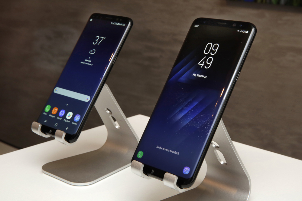 The new Samsung Galaxy S8, left, and S8 Plus are displayed in New York City. An optional docking station will turn an S8 into a desktop computer when connected to a regular TV.