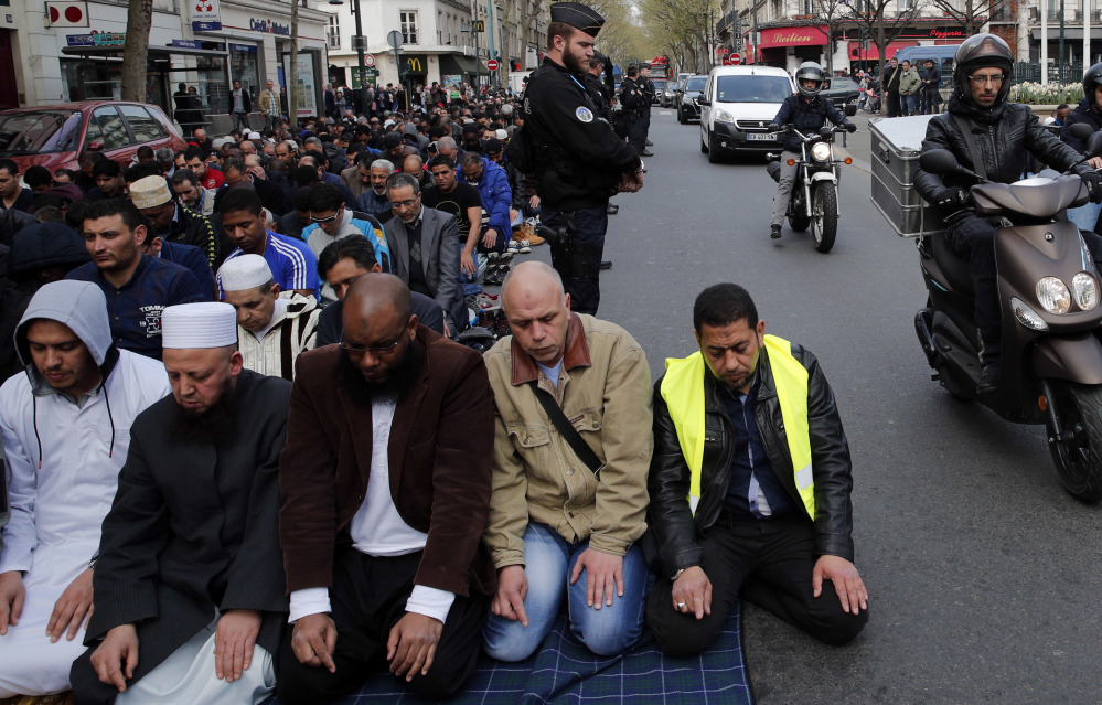 Hundreds of Muslims pray on the street in front of the town hall plaza in the Paris suburb of Clichy la Garenne on Friday.