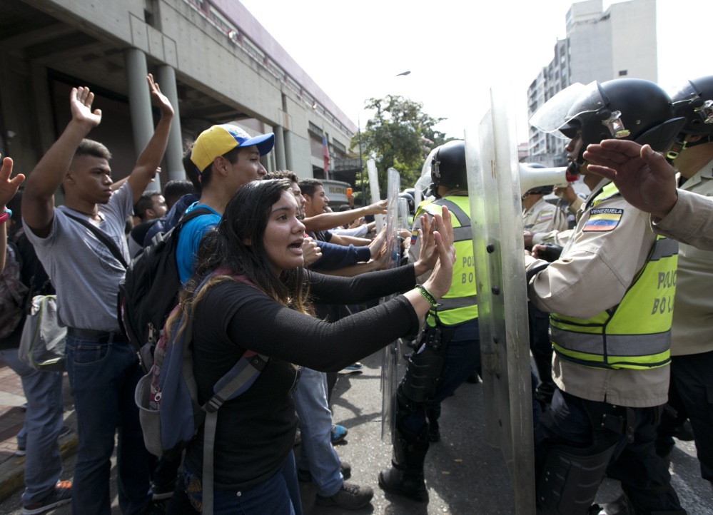 University students clash with Bolivarian National Police Officers during a protest in Caracas, Venezuela on Friday, Venezuelans have been thrust into a new round of political turbulence after the government-stacked Supreme Court gutted their congress of its last vestiges of power, drawing widespread condemnation from foreign governments and sparking protests in the capital.