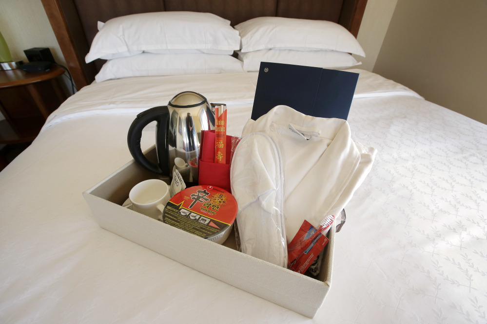 Items in a welcoming kit for Chinese travelers at the Sheraton Boston Hotel include from the left, an electric kettle, green tea, instant noodles, slippers and a robe.